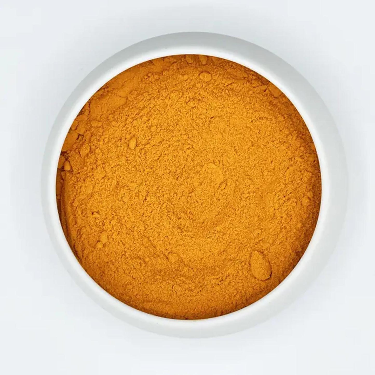 Draufsicht auf feines, goldgelbes Bio-Kurkumapulver in einer weißen Keramikschale auf hellem Hintergrund.