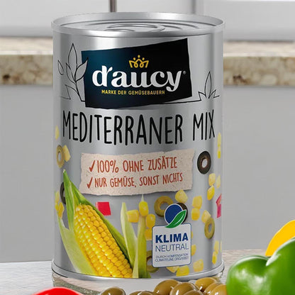 d'aucy Mediterraner Mix – Dose mit dampfgegartem Gemüse ohne Zusätze, Nutri-Score A und Klima-Neutral-Siegel vor einem Küchenhintergrund.
