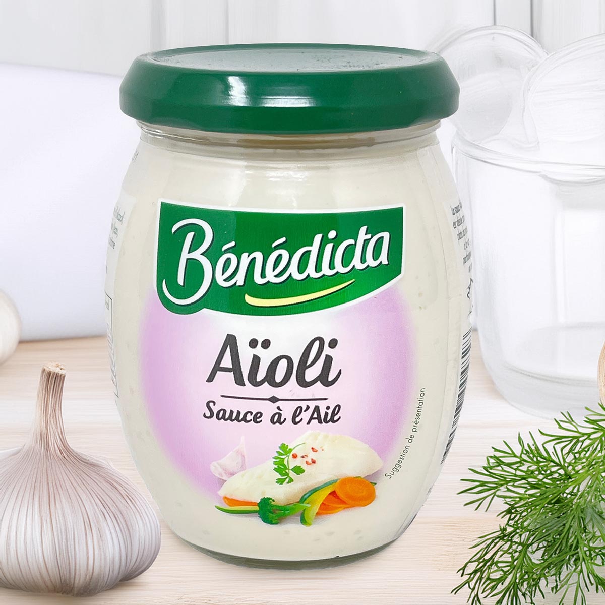 Bénédicta Aioli Sauce à l’Ail im 260 g Glas, cremige Knoblauchmayonnaise mit grünem Deckel, serviert mit Knoblauch und Kräutern auf hellem Hintergrund.