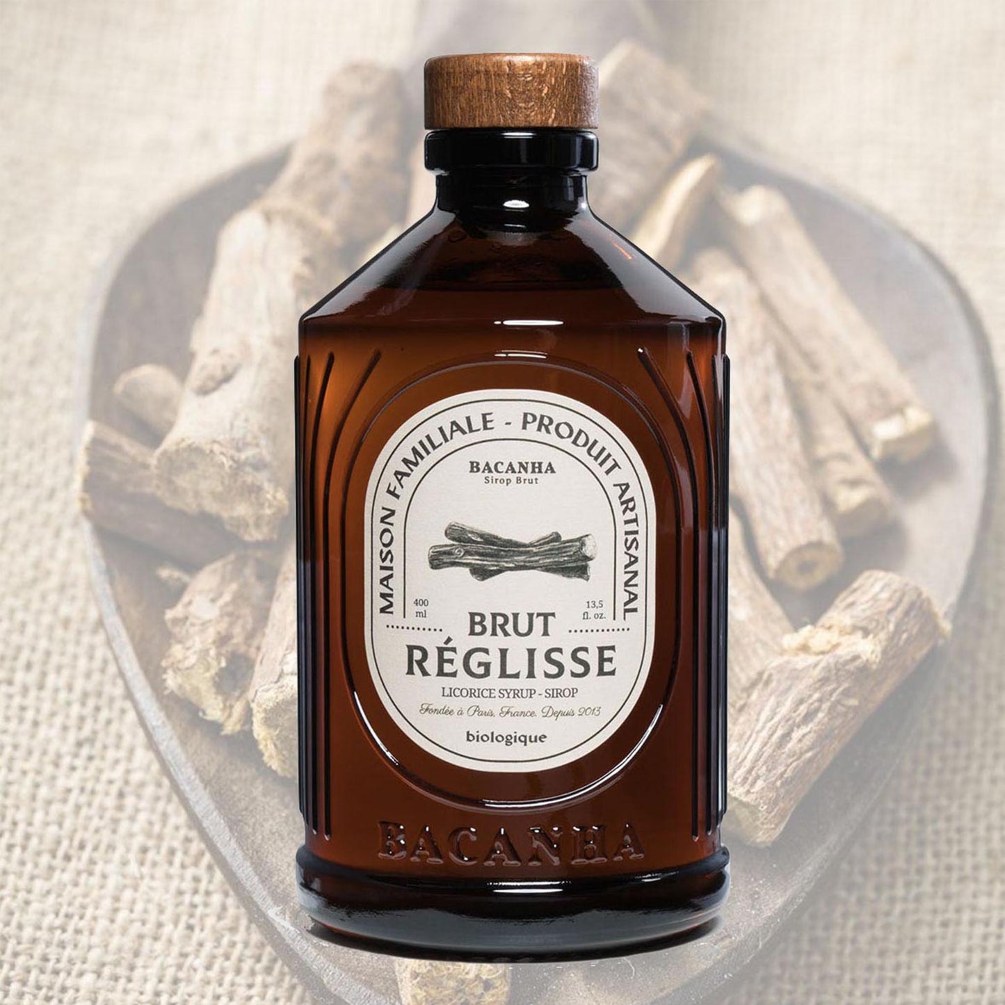 Bacanha Bio-Lakritz-Sirup (Sirop Brut de Réglisse) wird aus der 400ml Design-Glasflasche über eine Kugel Vanilleeis gegossen – ein Gourmet-Dessert mit Bio-Lakritzgeschmack.