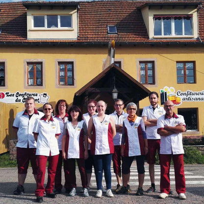 Team der Konfitürenmanufaktur Les Confitures du Climont vor dem Firmengebäude im Elsass, Mitarbeiter in Arbeitskleidung präsentieren handwerkliche Herstellung traditioneller Konfitüren.