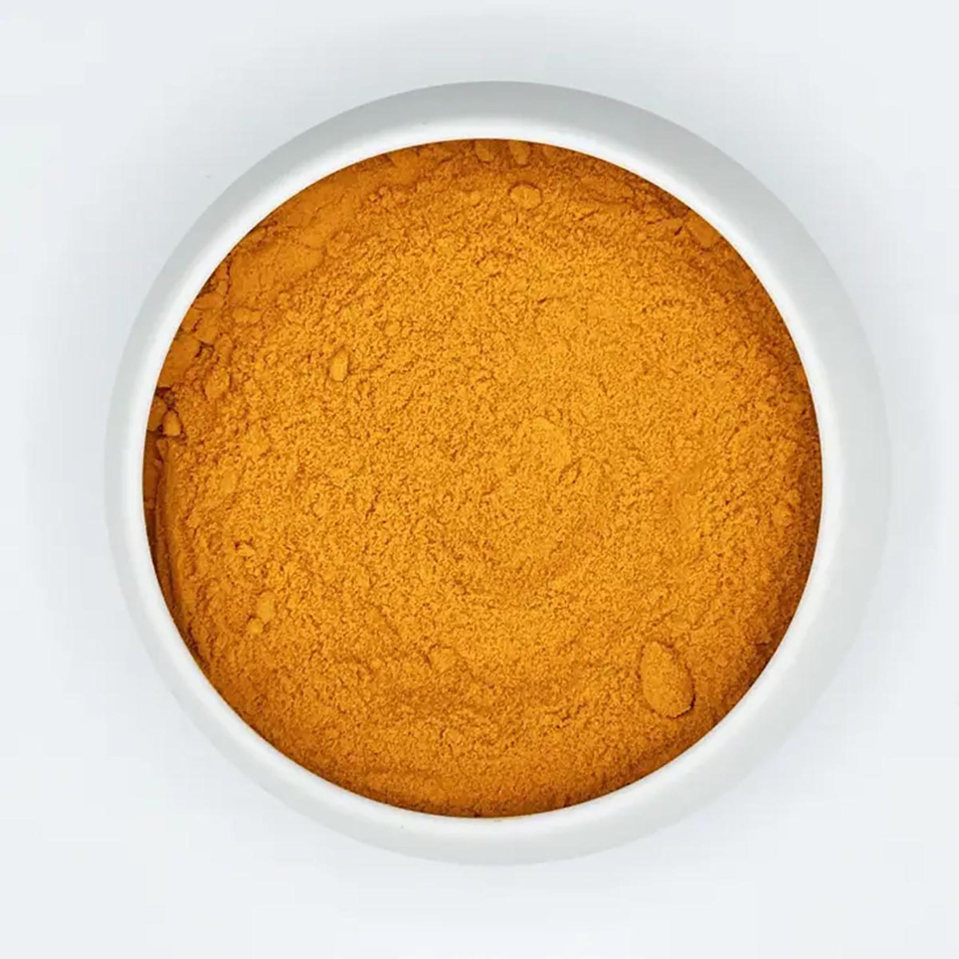 Draufsicht auf feines, goldgelbes Bio-Kurkumapulver in einer weißen Keramikschale auf hellem Hintergrund.