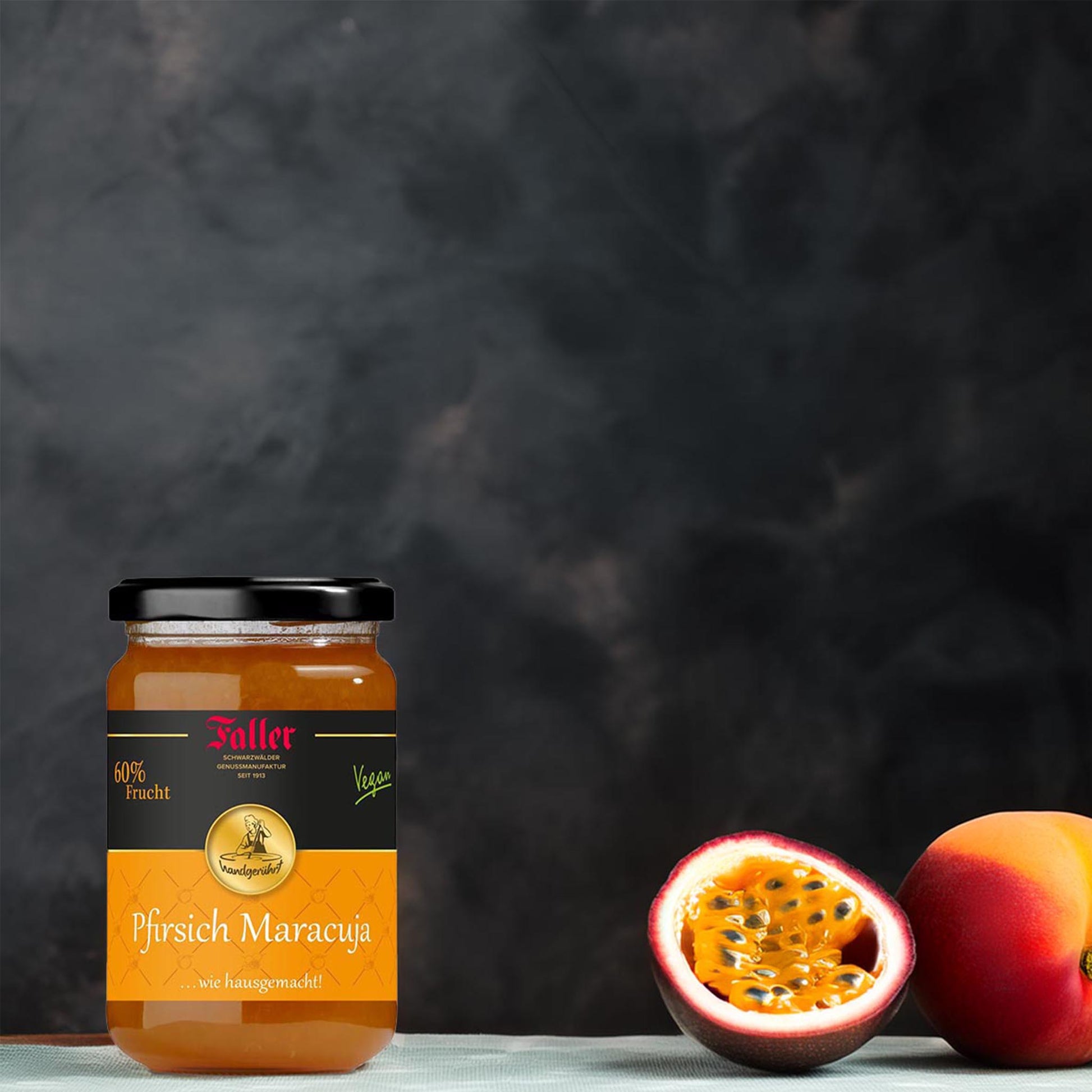 Faller Pfirsich-Maracuja Konfitüre im Glas mit 60 % Frucht, veganer Fruchtaufstrich aus dem Schwarzwald, arrangiert mit frischer Maracuja und Pfirsich auf dunklem Hintergrund, 330 g.