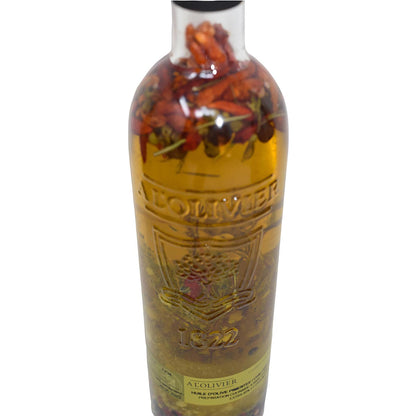 Nahaufnahme einer 500-ml-Glasflasche A L'Olivier Olivenöl mit Piment d’Espelette und Chili, die im Detail die eingeprägte Jahreszahl „1822“, das Markenlogo sowie die im Öl eingelegten ganzen Chilischoten und Kräuter zeigt.